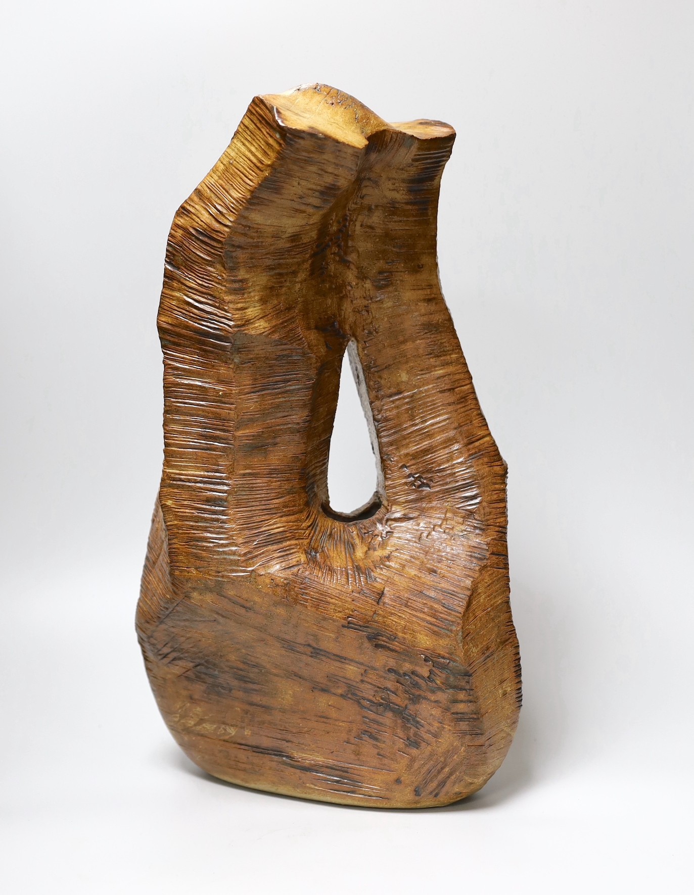 Ruth Sulke - a large brown copper glazed stoneware angular “wooden” sculpture with central hole, 1985, 42cm, See Sulke, Ruth - Ceramic Sculpture by Ruth Sulke, Hanart 2 Gallery, 1987, page 30